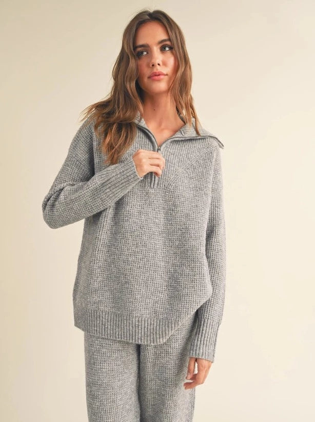 Waffle Sweater Top Waffle Pattern Quarter Zip Sweater Top 90% Polyester, 8% Nylon, 2% Spandex Color: Heather Grey This Waffle Sweater Top offers all the warmth and softness of a classic sweater, with the modern styling of a quarter-zip. Crafted with quality waffle knit fabric, this top is lightweight yet snug, providing comfort in temperatures from cool to cold.