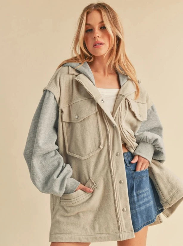 Irene Hooded Jacket Two toned jacket Button Up Pocket Details Hood 100% Polyester Color: Bone/Heather Gray Irene Jacket features a hood and button fastening, warm for a chilly day. The newness of the piece will turn heads and is crafted in built-to-last material.
