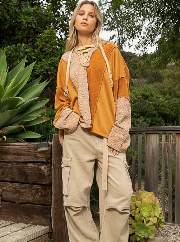 Lace Up Color Block Knit Top Designed in drawstring lace up with hood Long sleeves Oversize fit Out seam detailing Color blocked vintage wash knit panels Floral pattern quilted knit top