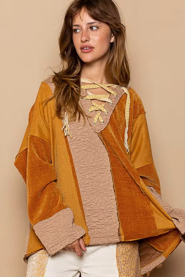 Lace Up Color Block Knit Top Designed in drawstring lace up with hood Long sleeves Oversize fit Out seam detailing Color blocked vintage wash knit panels Floral pattern quilted knit top