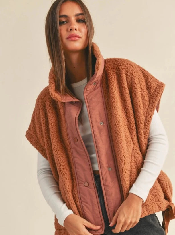 The Eldridge Jacket Teddy Fabric Utility Vest Jacket Button Details Pockets 100% Polyester Color: Chestnut Wrap your bundle of joy in this cozy Teddy Vest. Crafted with soft fabric, it is the perfect layer for your baby's comfort and warmth. This vest is ideal for any season.