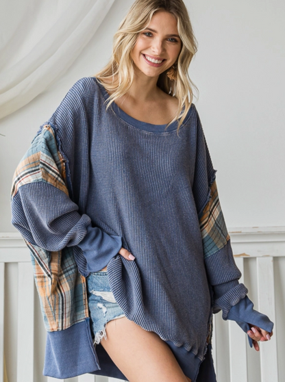 Wondering Washed Waffle Knit Sweater  Mineral Washed waffle knit Contrast plaid detail tunic Oversized Relaxed Fit Color: Blue Experience superior comfort and style with the Wondering Washed Waffle Knit Sweater. This oversized sweater features a soft waffle knit with eye-catching plaid arm patches. Perfect for any season, this unique sweater is a must-have in any wardrobe.