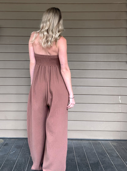 Moroccan Strapless Jumpsuit - Mocha  Wide leg strapless jumpsuit Twisted bust Wide leg Pockets 100% Cotton Color: Mocha Step out in style with this Moroccan Strapless Jumpsuit. This wide leg boho jumpsuit provides elegance and comfort. Crafted from quality materials, this jumpsuit will make a statement while keeping you comfortable throughout the day. Perfect for any special occasion.